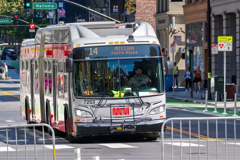 San Francisco Muni bus on street, line 14 with MISSION - Ferry Plaza" on front marquee.